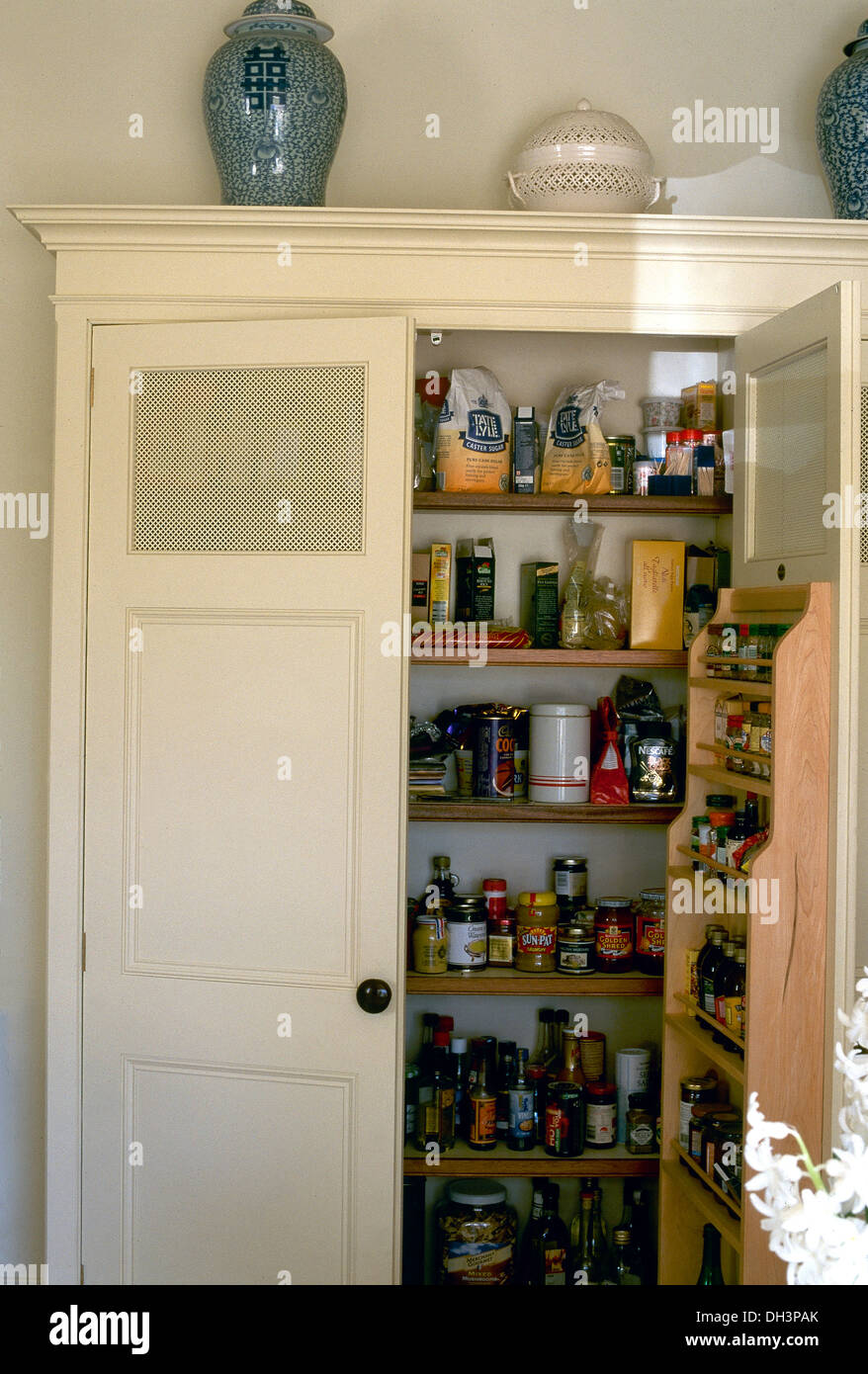 Costruito in dispensa Ripostiglio con porta integrale di scaffali e di  bottiglie e vasetti di prodotti alimentari Foto stock - Alamy