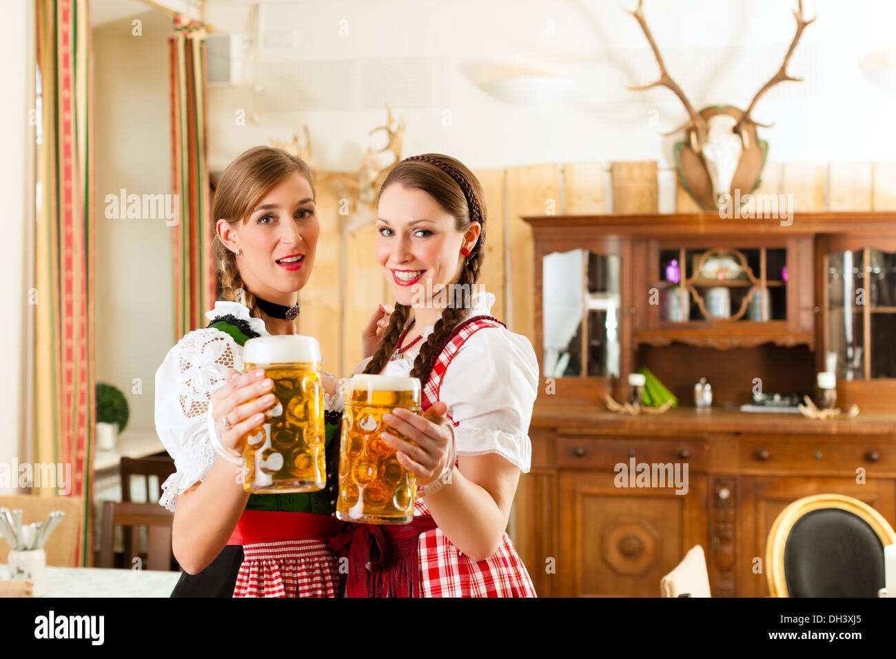 Giovani donne in tradizionali abiti bavarese - dirndl o tracht - su un festival o Oktoberfest in una tenda di birra Foto stock