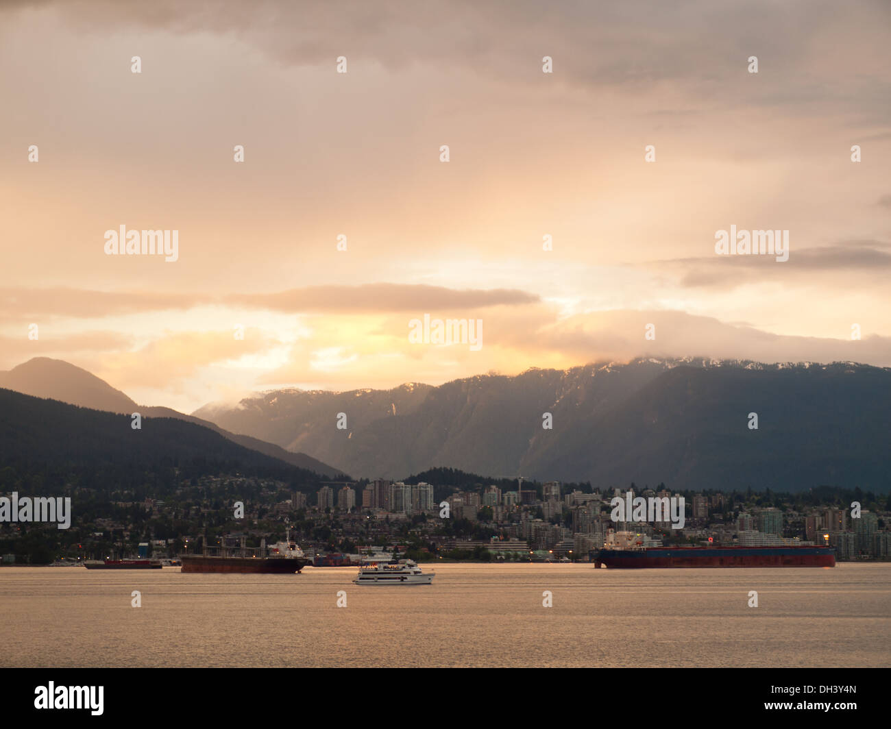 Suggestivo tramonto sopra il porto di Vancouver, North Vancouver, e Grouse Mountain come si vede dal centro cittadino di Vancouver, BC, Canada. Foto Stock