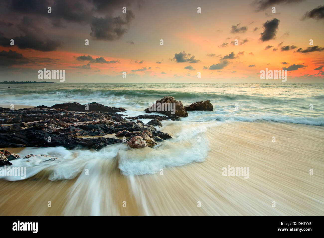 Le onde del mare linea gioco rock di impatto sulla spiaggia Foto Stock