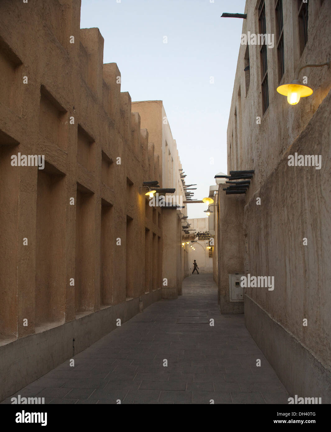 Lone uomo a camminare attraverso un vuoto back street di Doha Souk Waqif Foto Stock