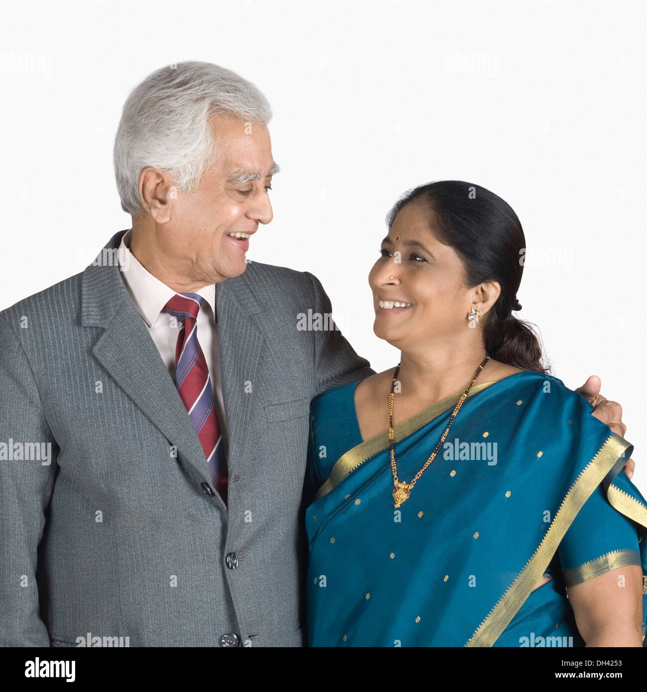 Senior uomo in piedi con il suo braccio intorno a una donna matura e sorridente Foto Stock