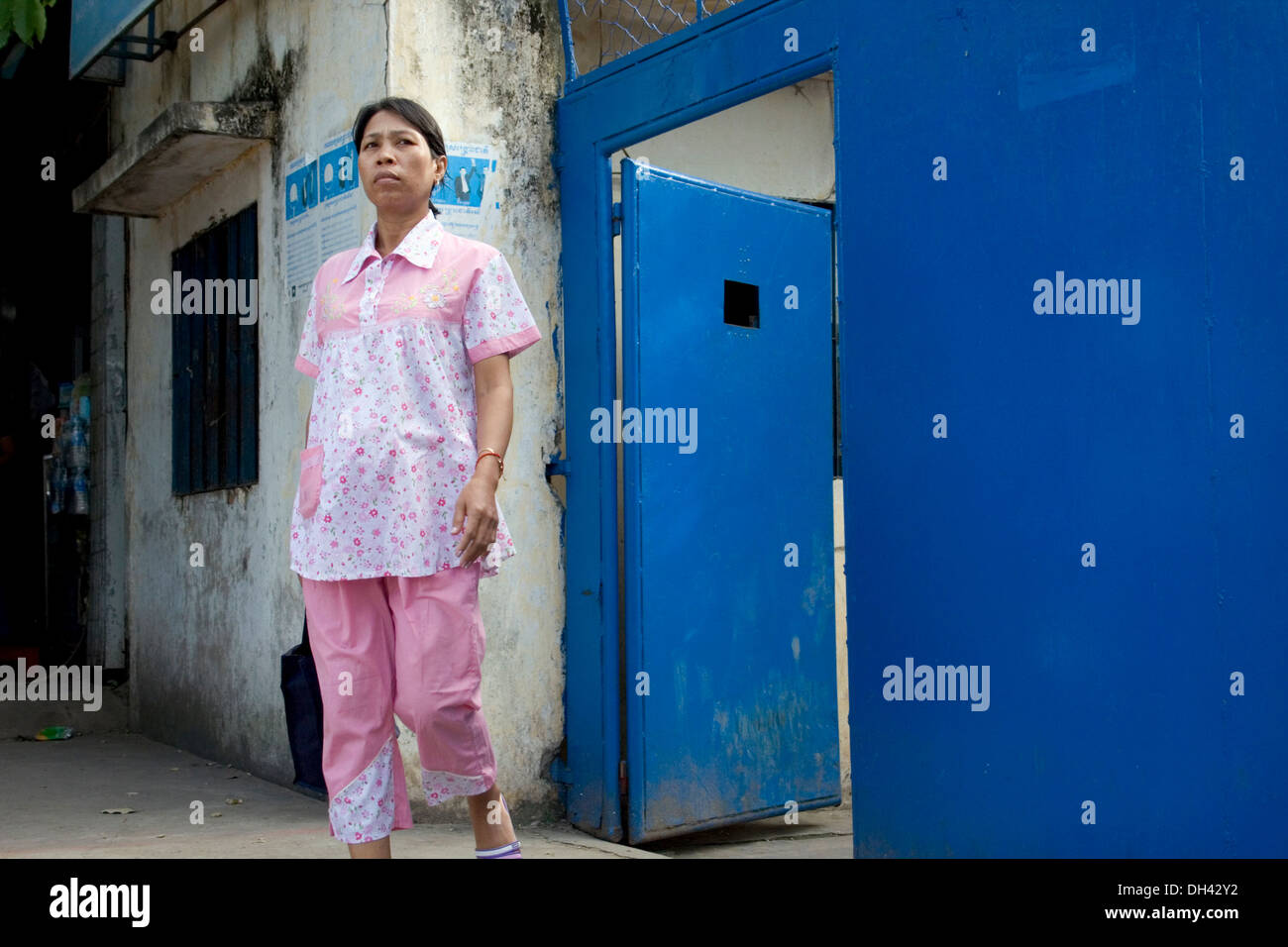 Una donna operaio di fabbrica è di lasciare un indumento in fabbrica dopo il turno in Phnom Penh Cambogia. Foto Stock