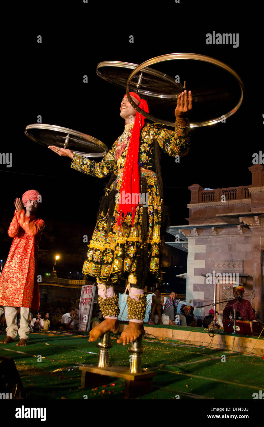 Uomo di bilanciamento del ciclo di tre ruote in piedi sui bicchieri jodhpur India Foto Stock