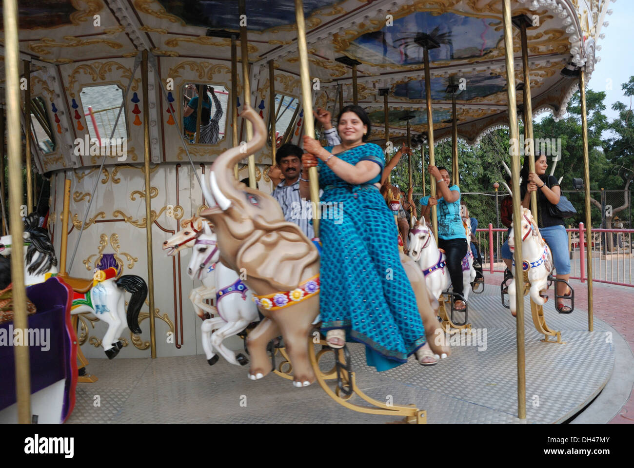 La donna a Merry Go Round cavallo in Ramoji Film City a Hyderabad, Andhra Pradesh in India Signor#704 Foto Stock