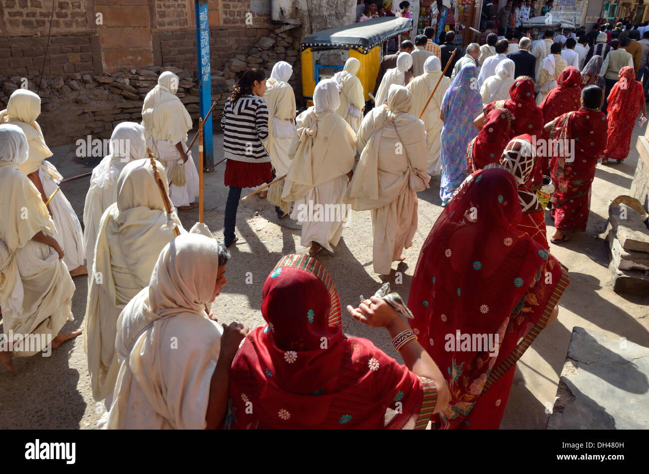 Jain monaci monache in abito bianco processione con le donne in rosso sarees Jodhpur Rajasthan India Asia Foto Stock