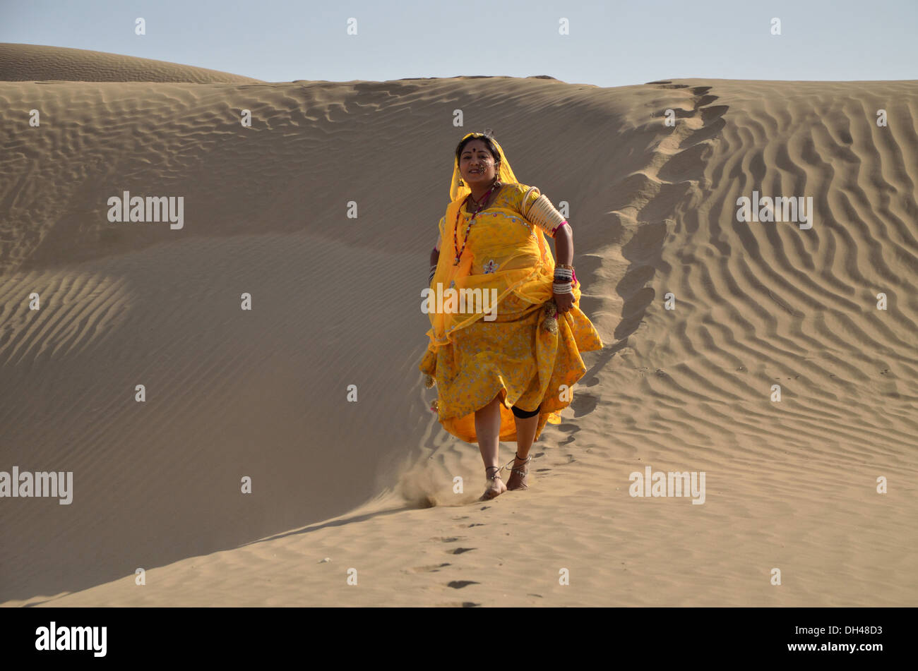 Donna indiana in esecuzione nel deserto di dune di sabbia del Rajasthan India Asia signor#704J Foto Stock
