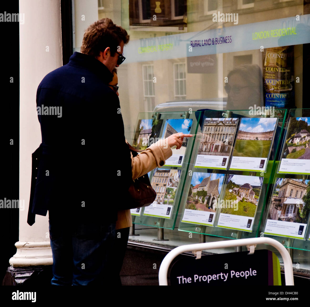 Coppia giovane guardando i beni di un agenzia immobiliare finestra nella vasca da bagno Somerset England Regno Unito Foto Stock
