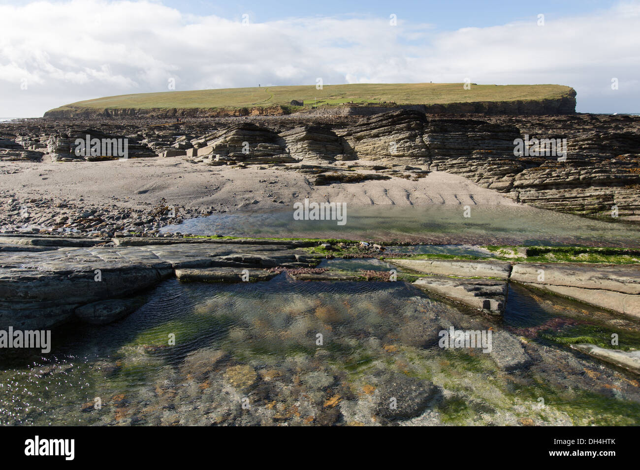 Isole di Orkney, Scozia. La bassa marea vista dall'Orkney's terraferma all'isola di marea, Brough di Birsay. Foto Stock