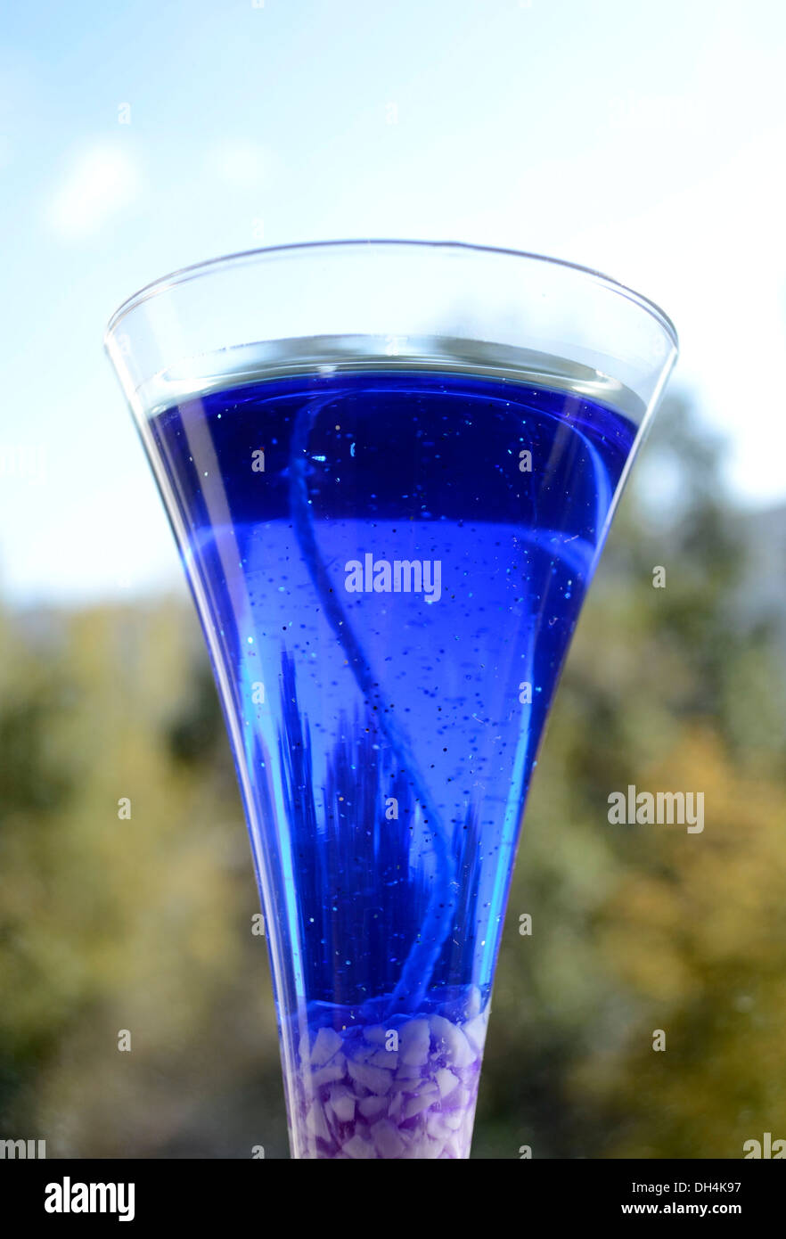 Candela blu in vetro su sfondo finestra Foto Stock