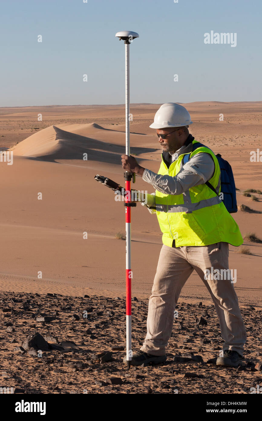 Geometra geologico utilizzando il GPS differenziale di attrezzatura per un digital terrain sondaggio nelle dune del deserto del Sahara, Mauritania Foto Stock