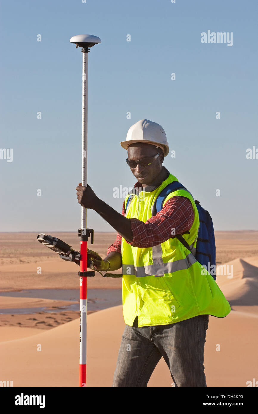 Geometra geologico utilizzando il GPS differenziale di attrezzatura per un digital terrain sondaggio nelle dune del deserto del Sahara, Mauritania Foto Stock