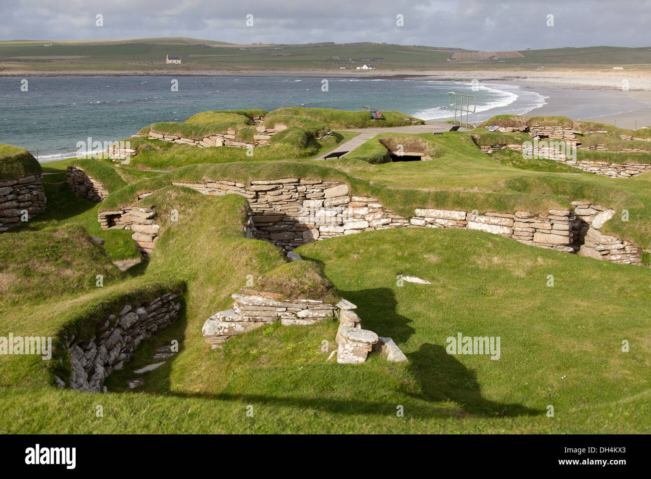 Isole di Orkney, Scozia. L'insediamento neolitico a Skara Brae, con la baia di Skaill in background. Foto Stock