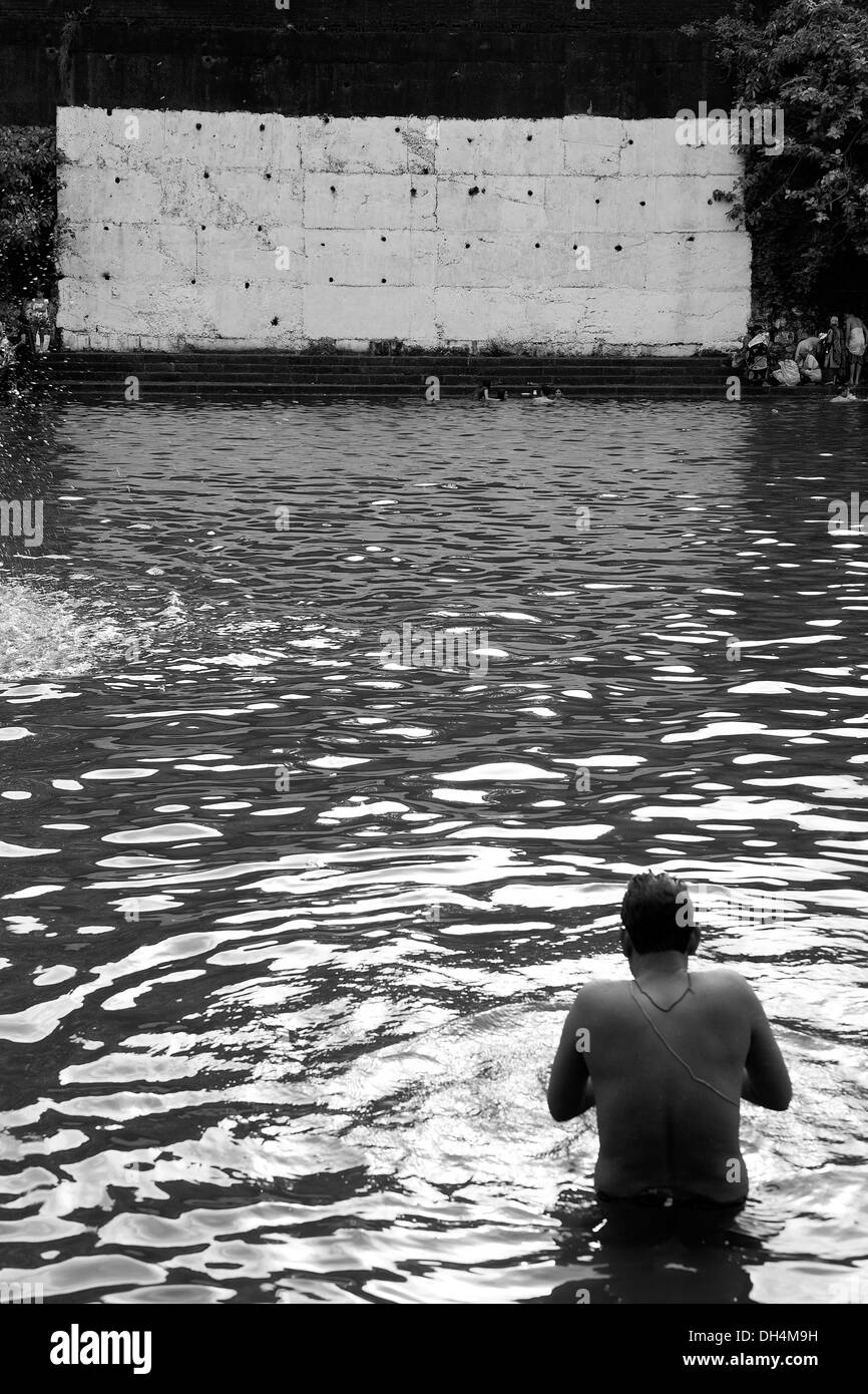 Muro Bianco e uomo che prega in Banganga Serbatoio acqua Walkeshwar Mumbai India Maharashtra 2012 Foto Stock