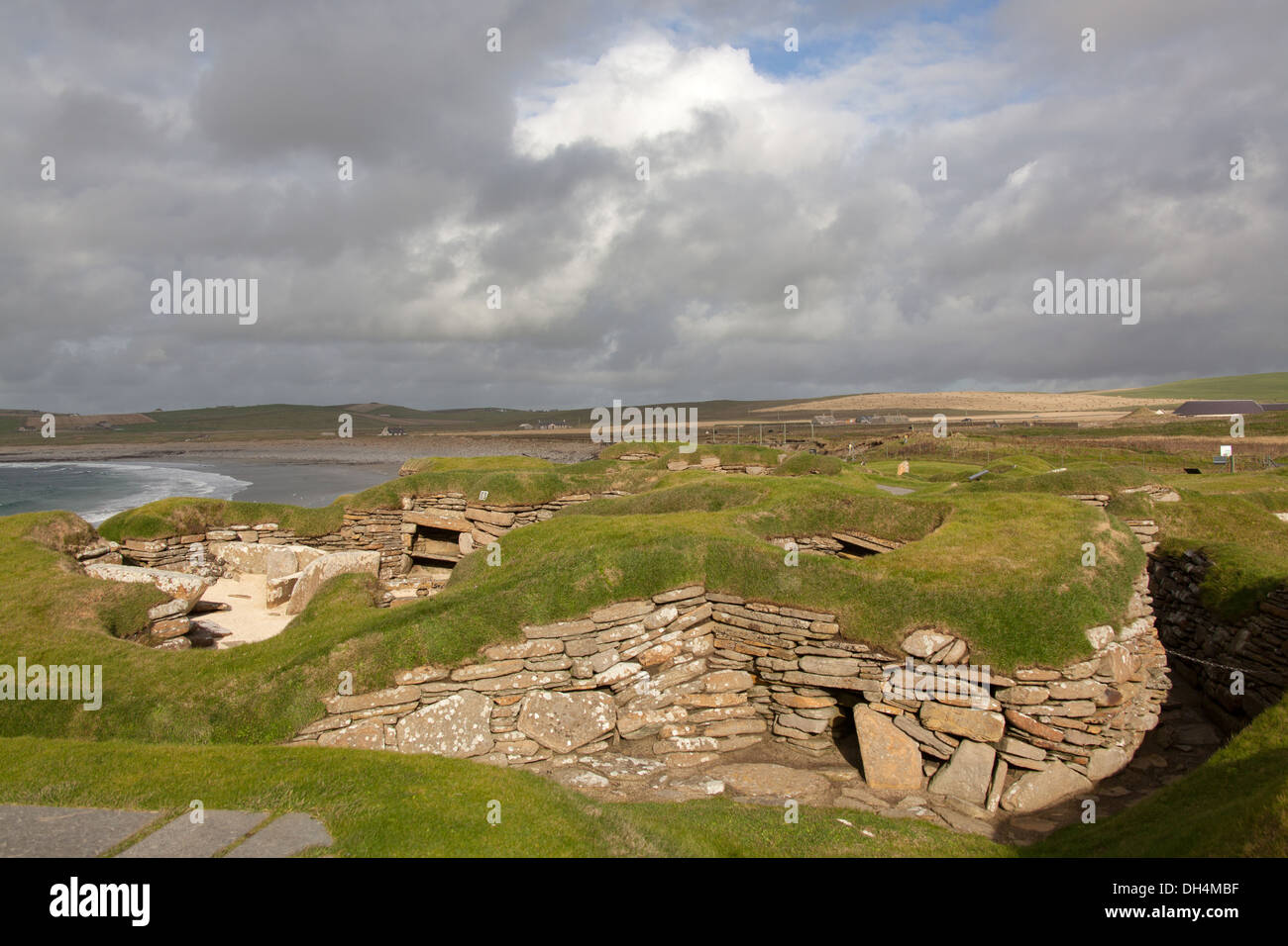 Isole di Orkney, Scozia. L'insediamento neolitico a Skara Brae, con la baia di Skaill in background. Foto Stock