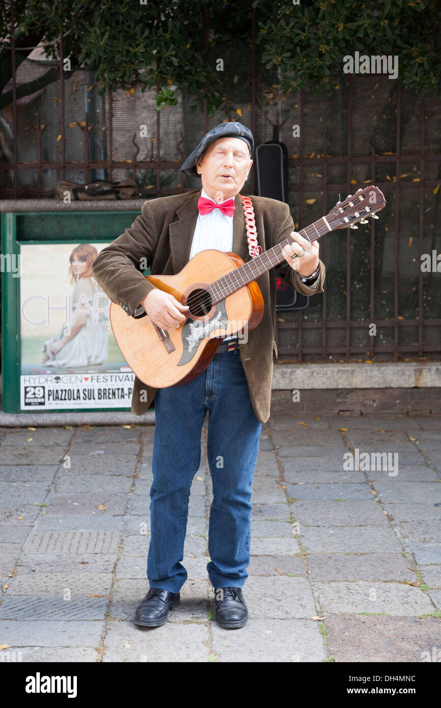 Un cantante di strada effettuando in corrispondenza di San Rocco piazza vicino alla omonima chiesa e la Scuola Grande (Venezia - Italia). Chanteur des rues. Foto Stock