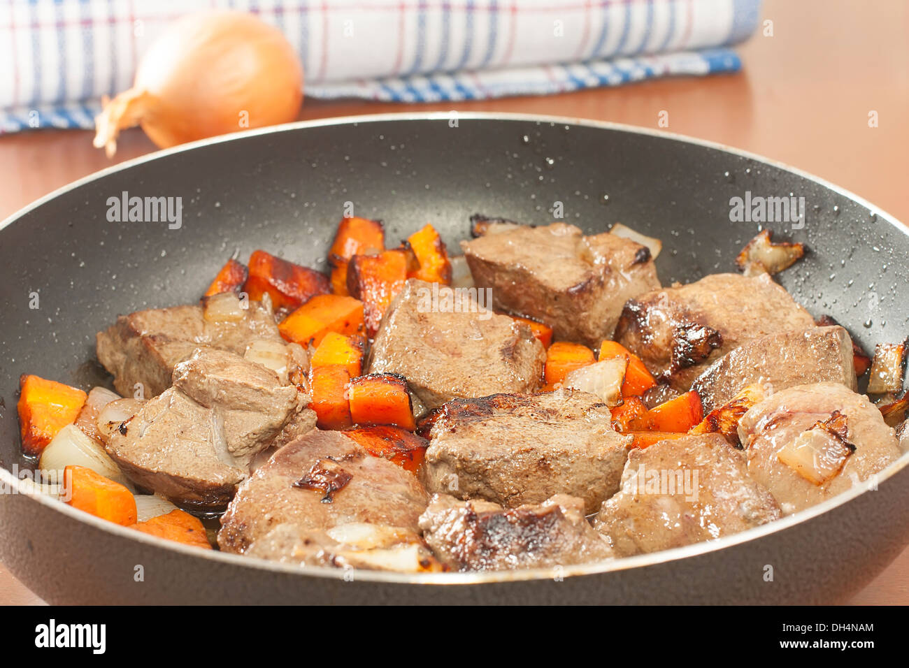 Le fette di fegato di manzo saltato con verdure in una padella Foto Stock