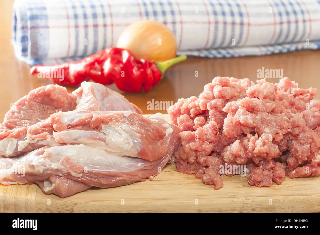 Interi pezzi di carne di manzo crudo con carne macinata su un tagliere Foto Stock