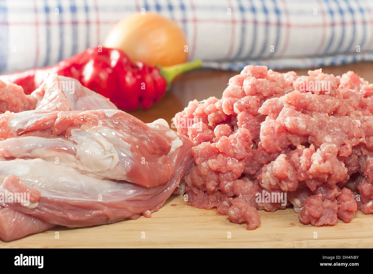 Interi pezzi di carne di manzo crudo con carne macinata su un tagliere Foto Stock