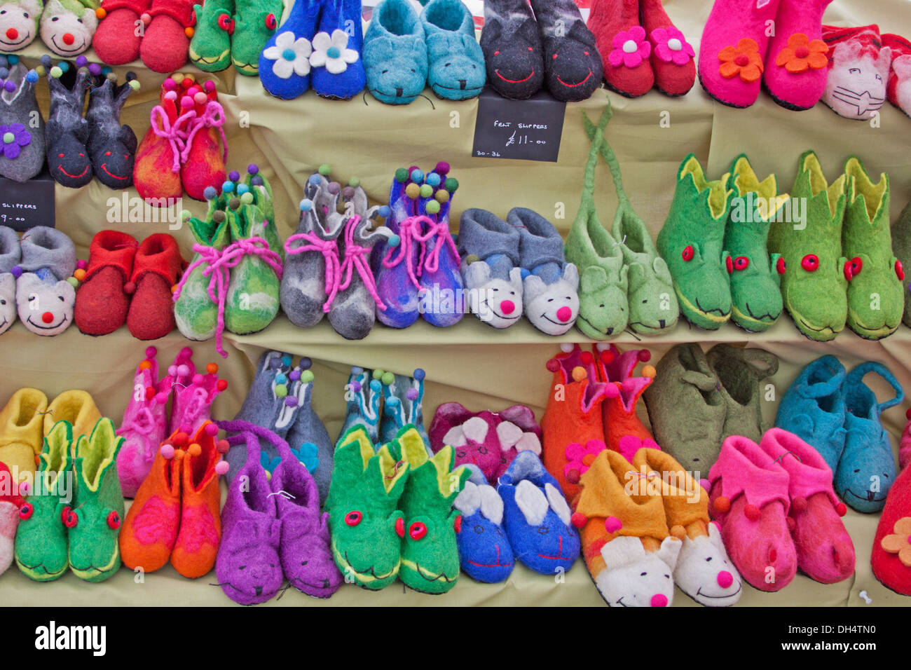 Colorato le calzature per bambini a forma di piccoli animali per la vendita su un mercato in stallo nel Devon Regno Unito Foto Stock
