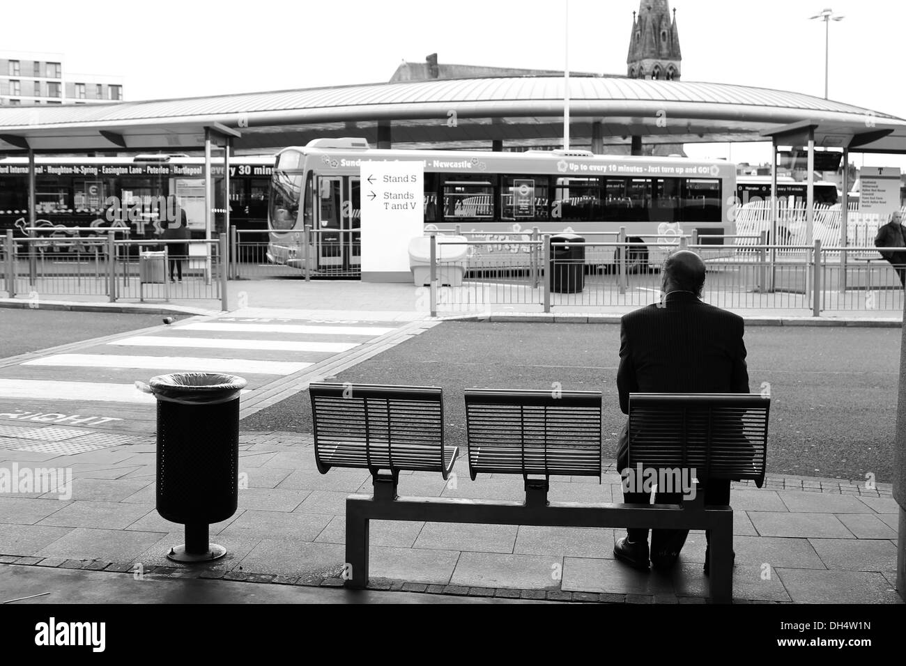 Il vecchio uomo in attesa per il bus Foto Stock