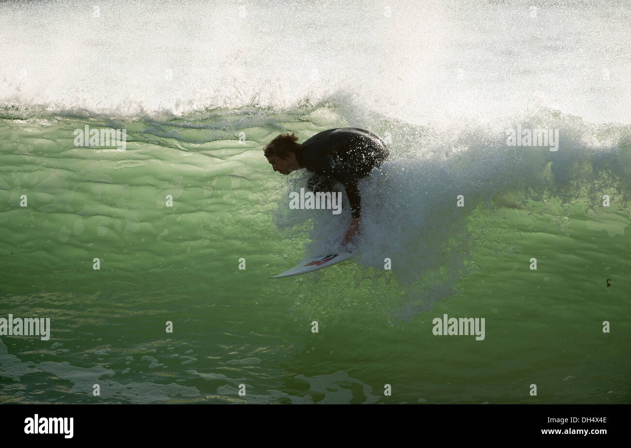 Surfer andando verso il basso in un tubo, false bay, sud africa Foto Stock