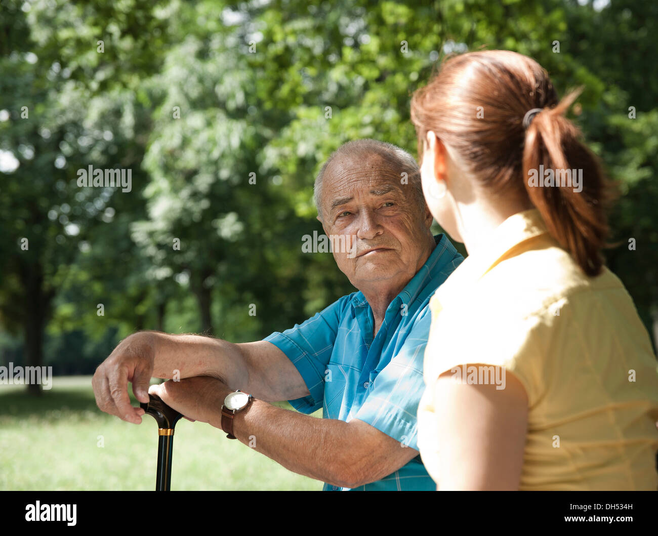 Una donna e un uomo anziano avente una chat in un parco Foto Stock