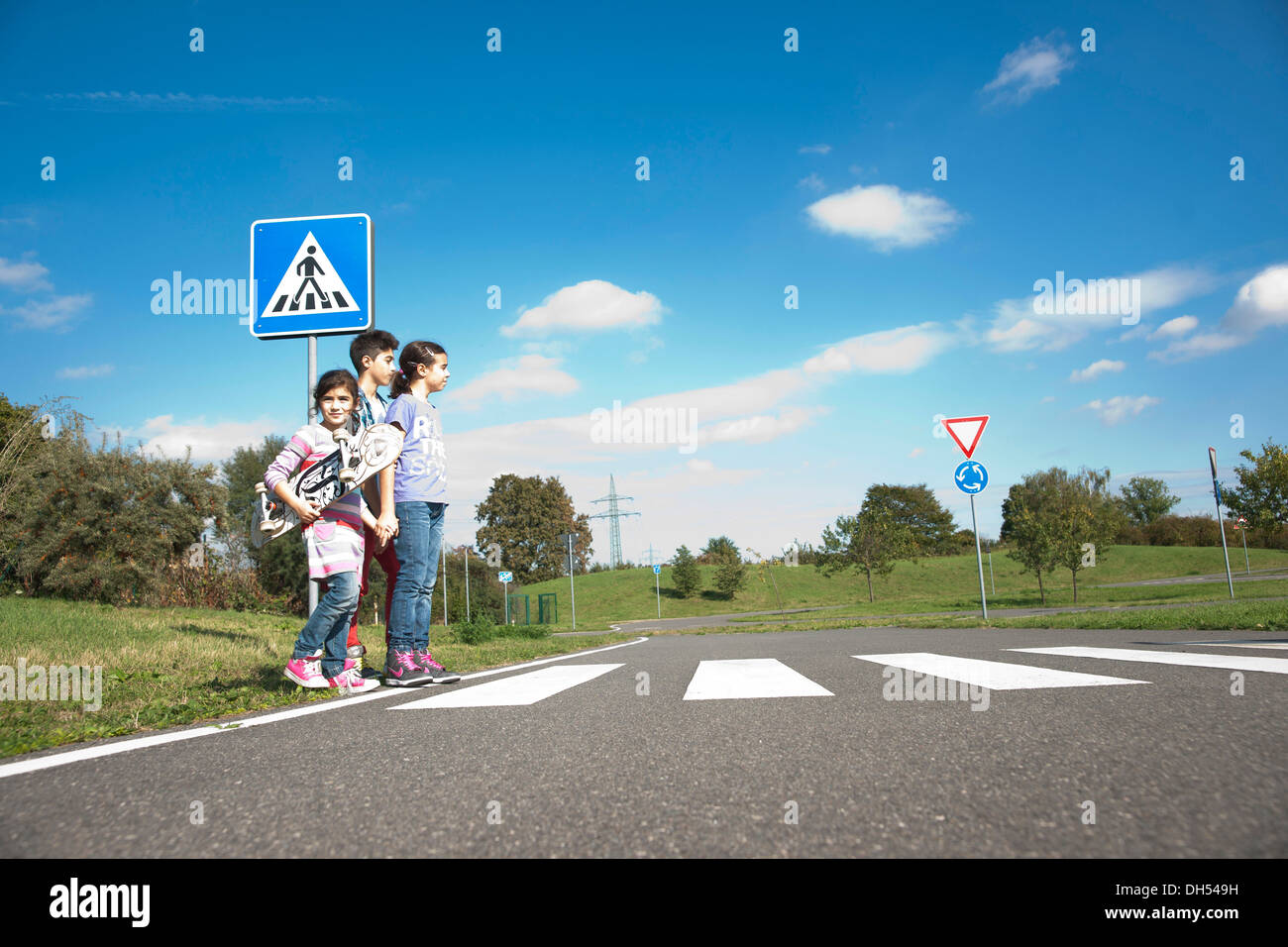 I bambini attraversando una zebra crossing Foto Stock