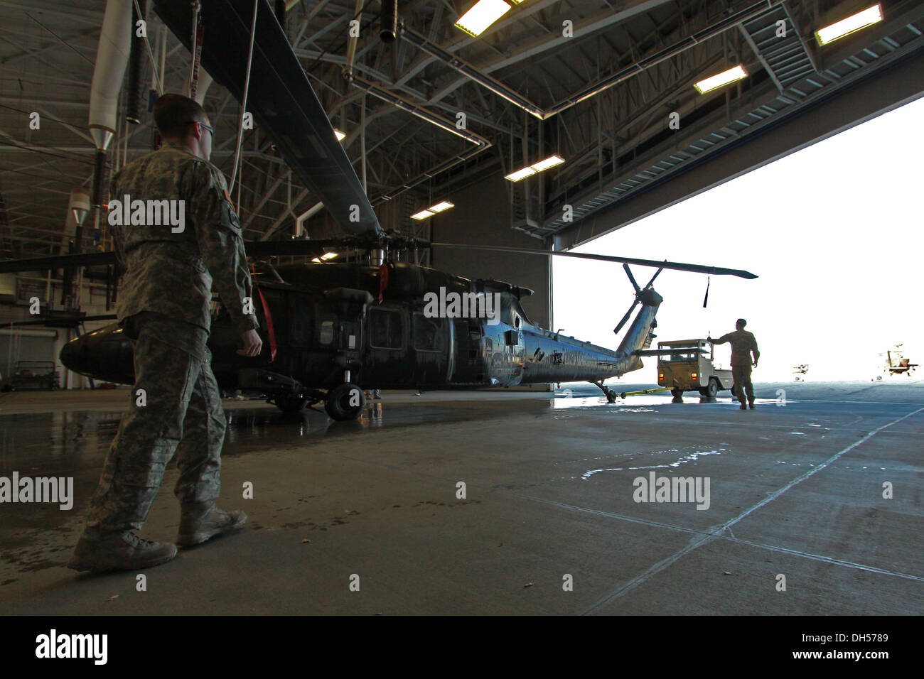 Equipaggio capi da 2-158th elicottero d'assalto battaglione, xvi combattere la Brigata Aerea rimuovere un UH-60M Black Hawk da un hangar Foto Stock