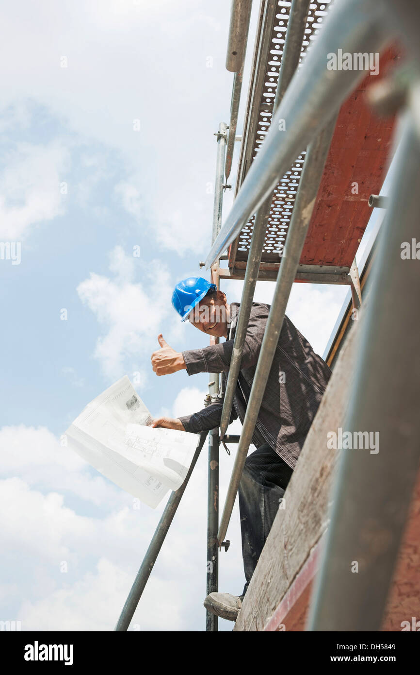 Soddisfatto construction manager facendo un pollice in su il gesto, Mannheim, Baden-Württemberg, Germania Foto Stock