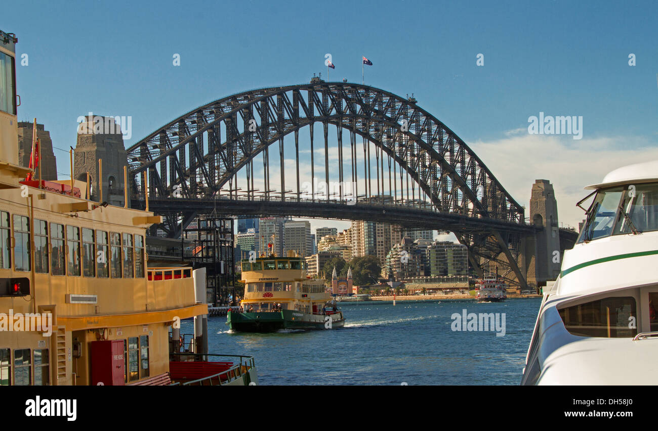 Il Sydney Harbour Bridge su acque blu del Darling Harbour con traghetto di " commuters " passando da e visualizzati da tra gli altri traghetti Foto Stock