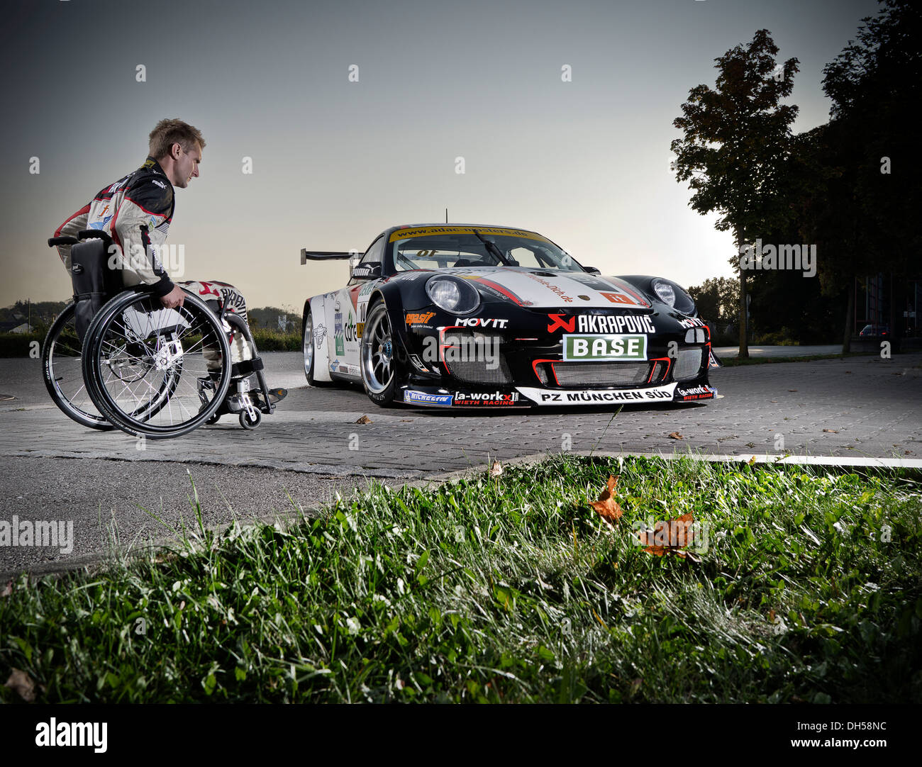 Race Car driver in una sedia a rotelle, accanto alla sua Porsche race car, Monaco di Baviera, Baviera, Baviera, Germania Foto Stock