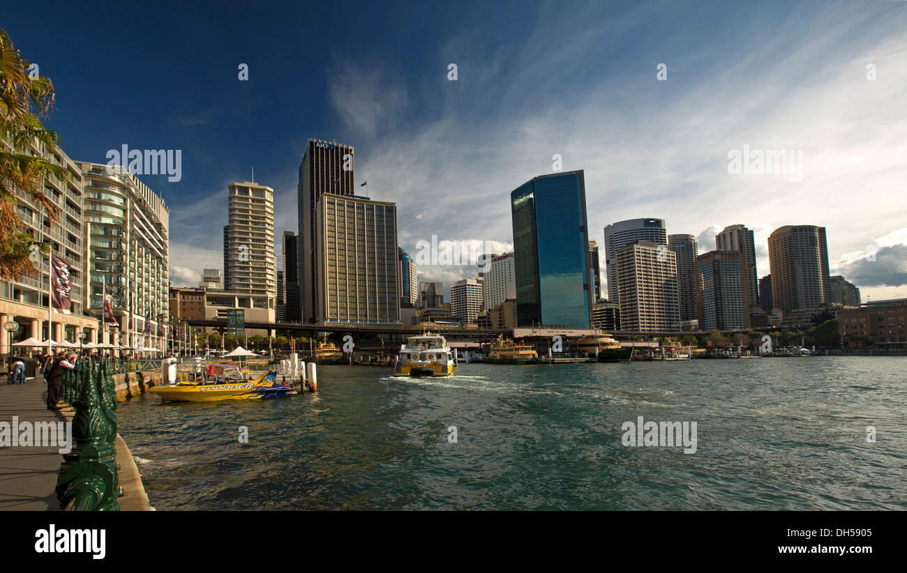 Alto edificio edifici della città, blocchi di appartamenti e barche accanto all acqua blu al Circular Quay sul porto di Sydney NSW Australia Foto Stock