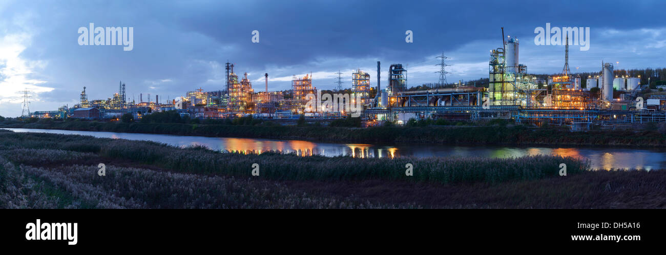 Le luci della sera dalla Ineos Chlor prodotto chimico industriale opere sul fiume Mersey estuario a Runcorn Cheshire Regno Unito Foto Stock