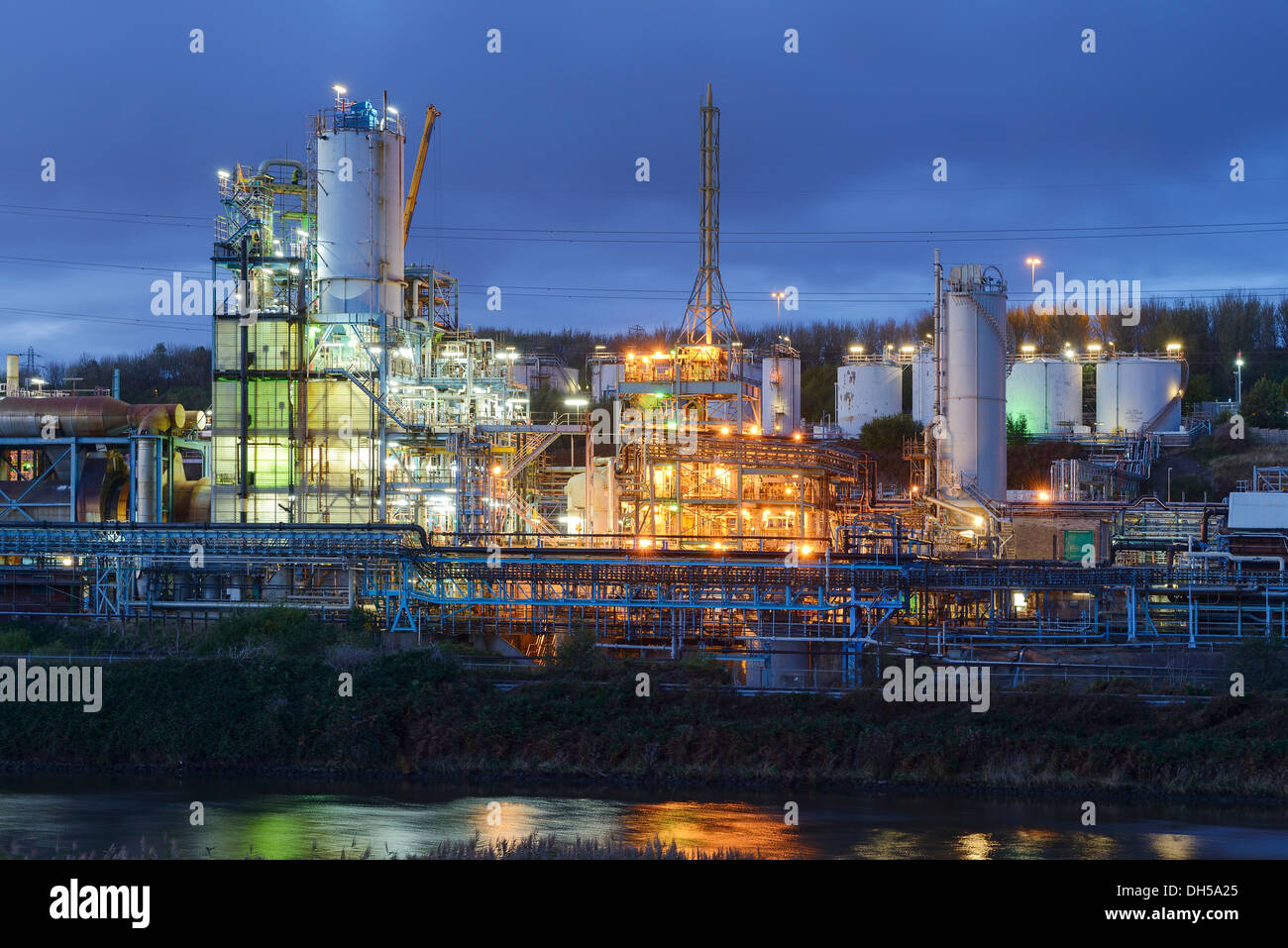 Le luci della sera da parte di Ineos Chlor prodotto chimico industriale opere sul fiume Mersey estuario a Runcorn Cheshire Regno Unito Foto Stock