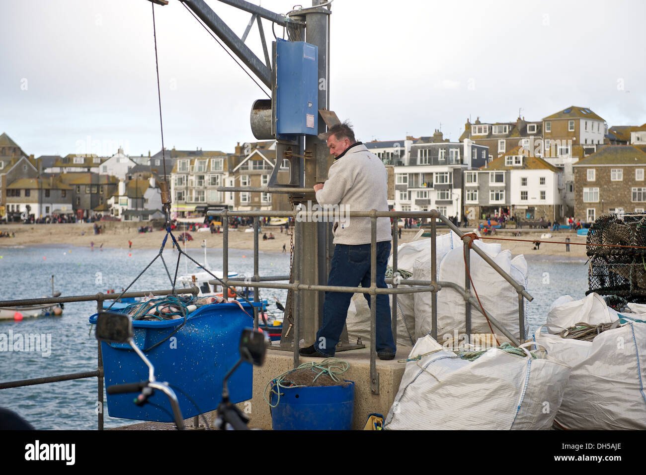 Fisherman utilizza un argano gru a terra una cattura di pesce sul porto keyside a St Ives Cornwall Regno Unito Foto Stock