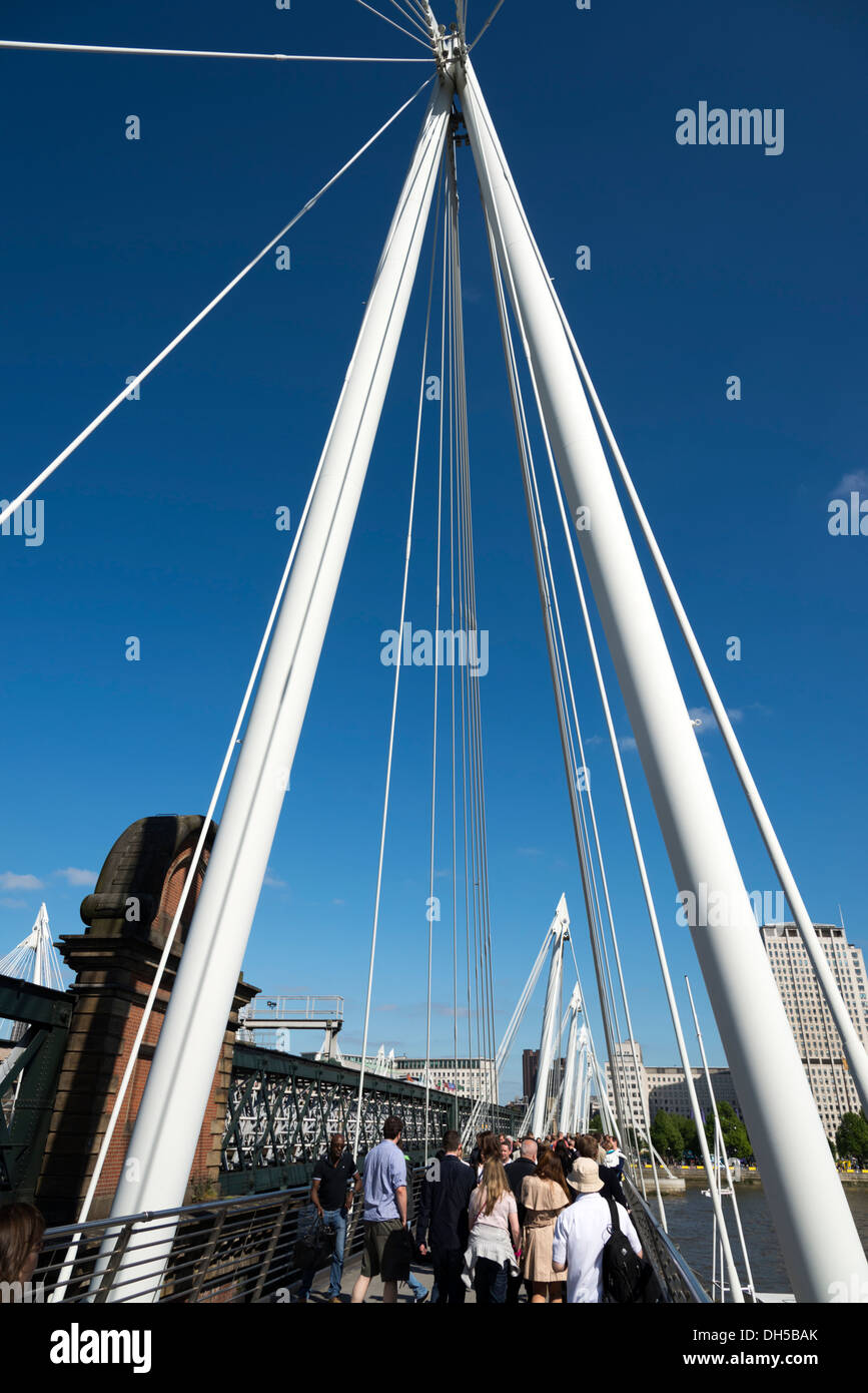 Le persone che attraversano il fiume Tamigi su uno del Giubileo d oro ponti , London, England, Regno Unito Foto Stock