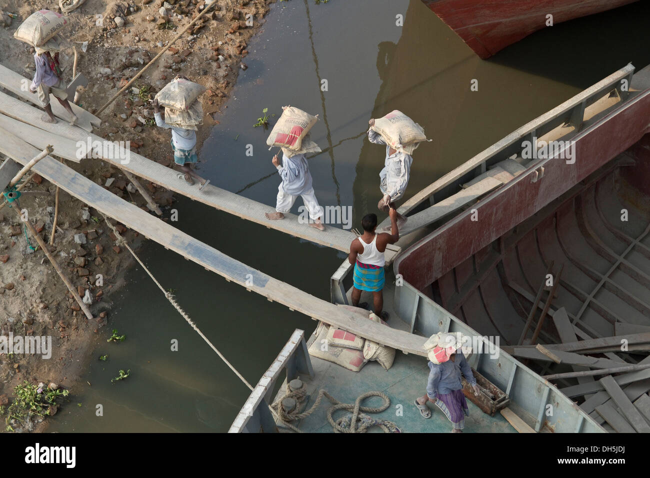 I vettori lo scarico di una nave con sacchi di cemento, Fiume Turag, Gabtoli, Dhaka, Bangladesh, Asia del Sud, Asia Foto Stock