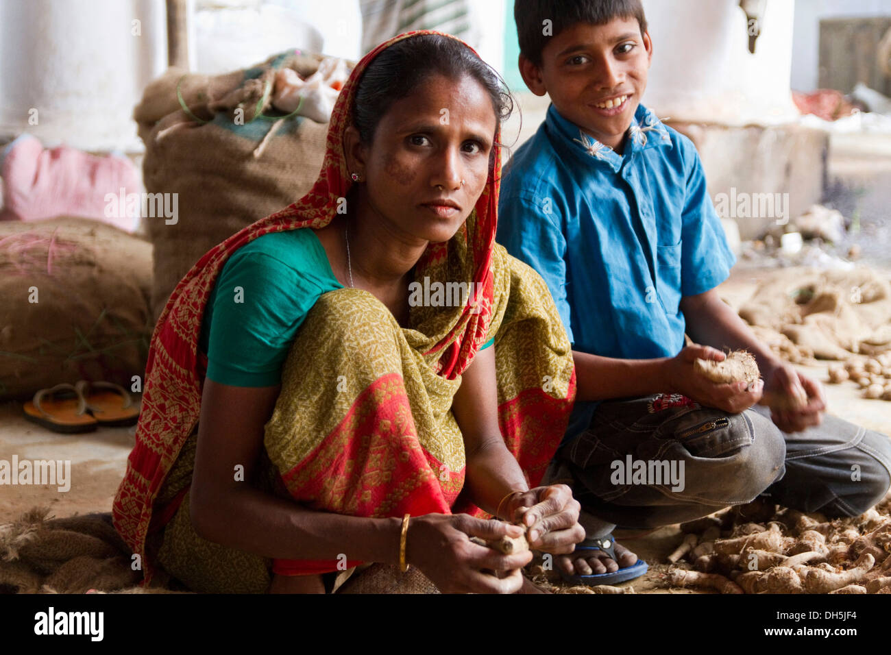 Una donna e un ragazzo di radici di smistamento, il mercato delle spezie, Old Dhaka, Dhaka, Bangladesh Asia del Sud Foto Stock