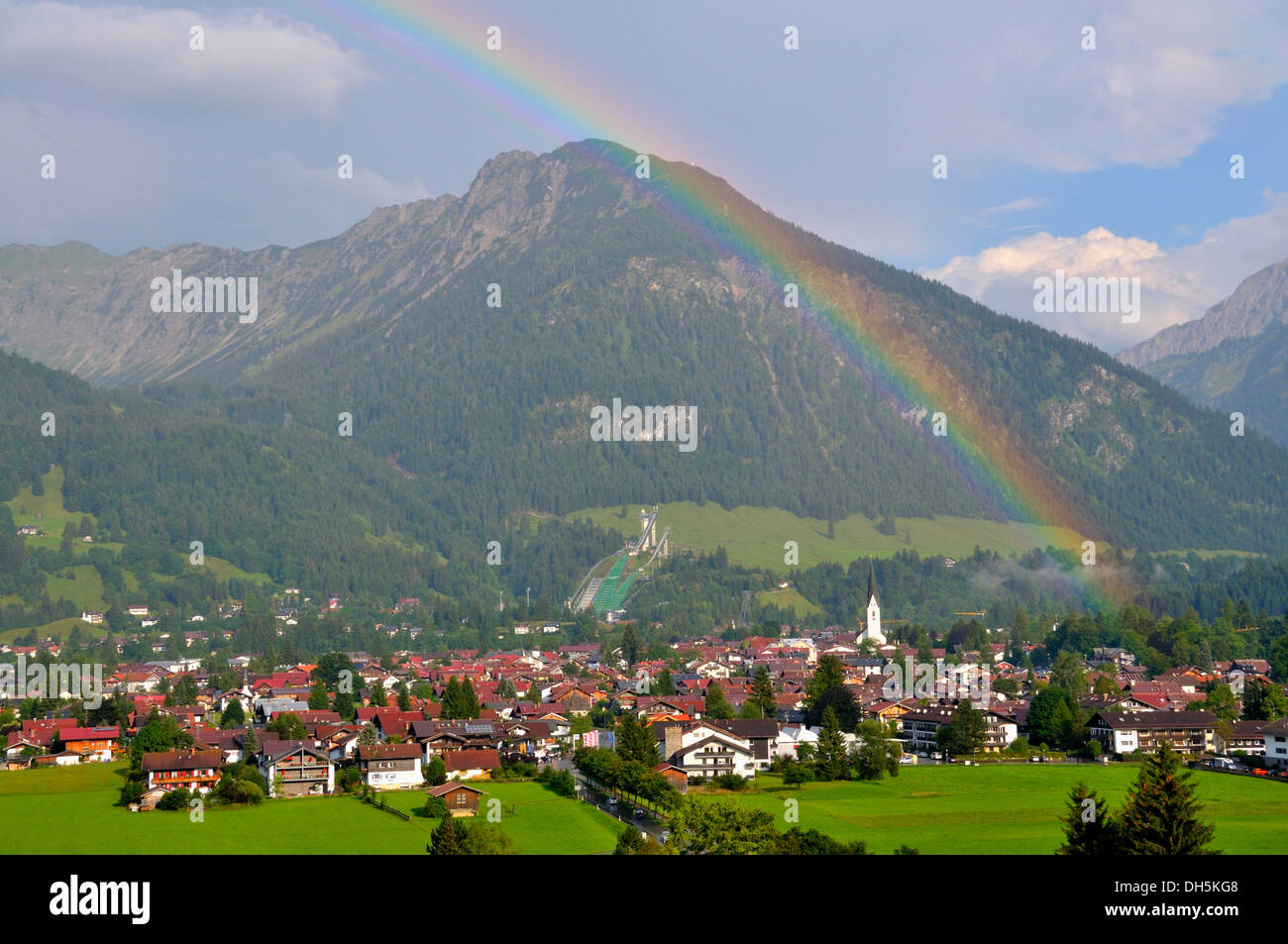 Vista su tutta Oberstdorf con arcobaleno, Schattenberg montagna con Schattenberg ski jump sul retro, Oberallgaeu distretto, Bavaria Foto Stock