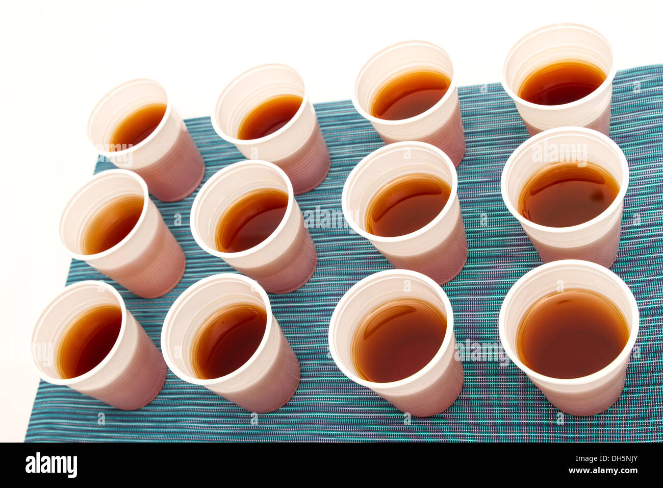Un sacco di tazze monouso con tè su uno sfondo colorato Foto Stock