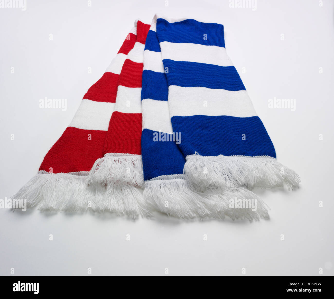 Sciarpe da calcio rosse e bianche e blu e bianche disposte l'una sull'altra su sfondo bianco Foto Stock