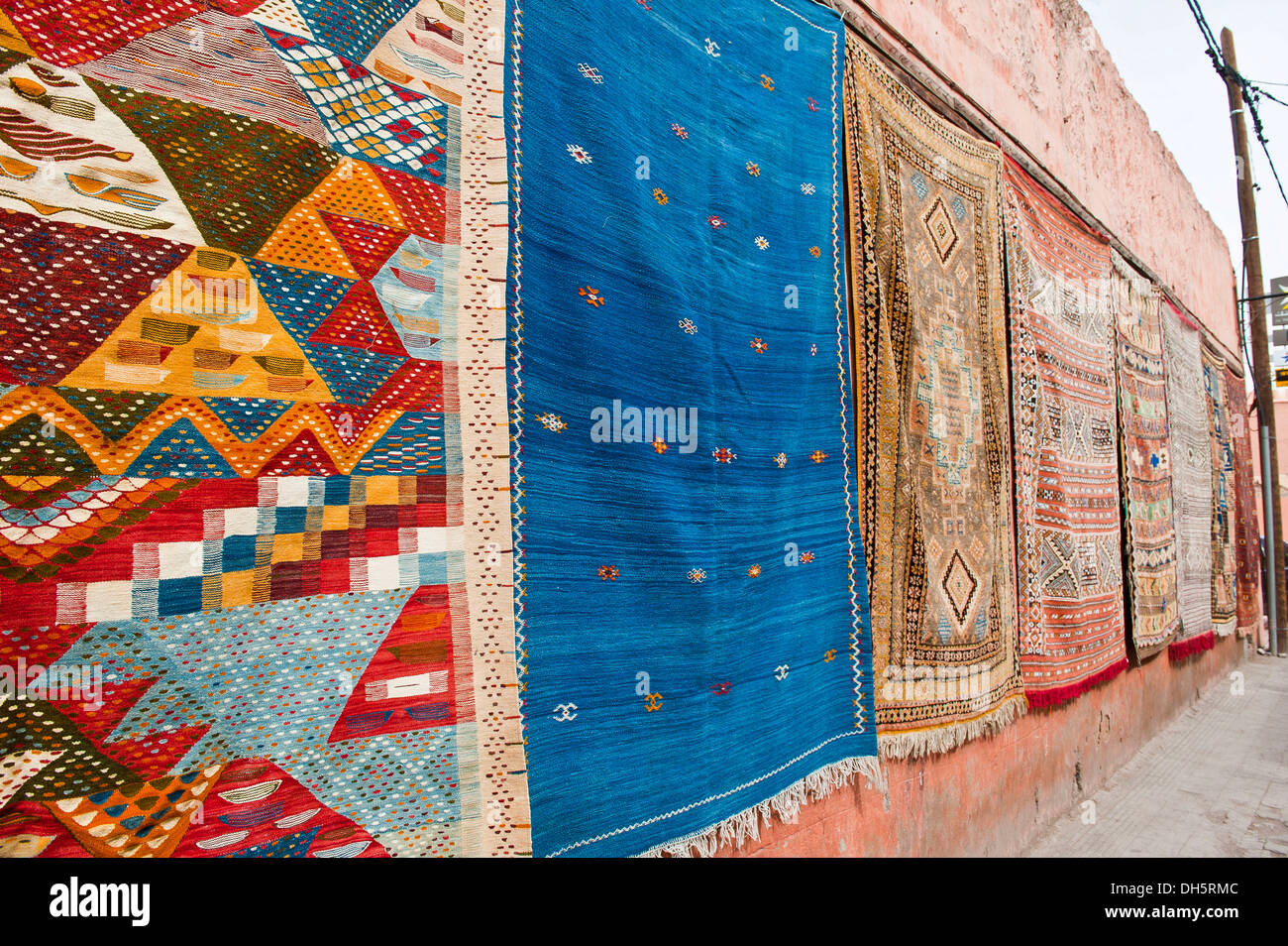 Moquette o tappeti con gli arabi e i simboli di Berbera e modelli, appeso a una facciata in vendita a Marrakech, Marocco, Africa Foto Stock