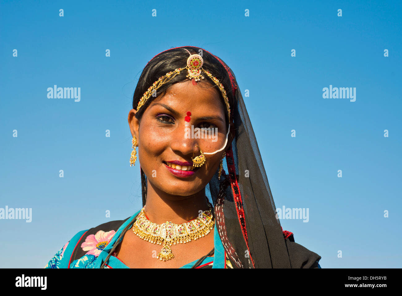Sorridente giovane donna indiana con un velo e gioielli, ritratto, Pushkar, Rajasthan, India Foto Stock