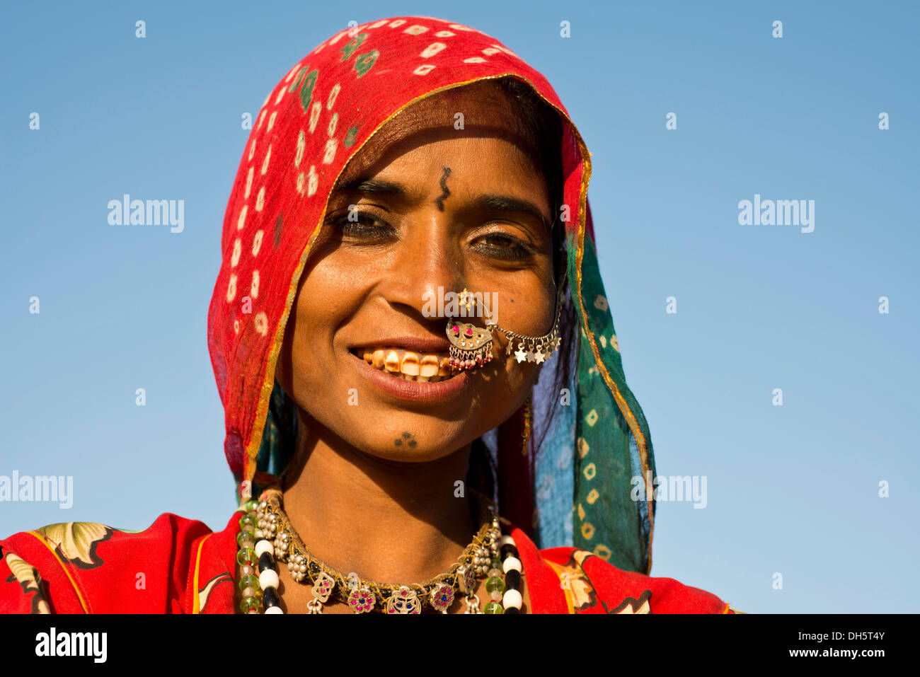 Sorridente giovane donna indiana con una sciarpa colorata e gioielli, ritratto, Pushkar, Rajasthan, India Foto Stock
