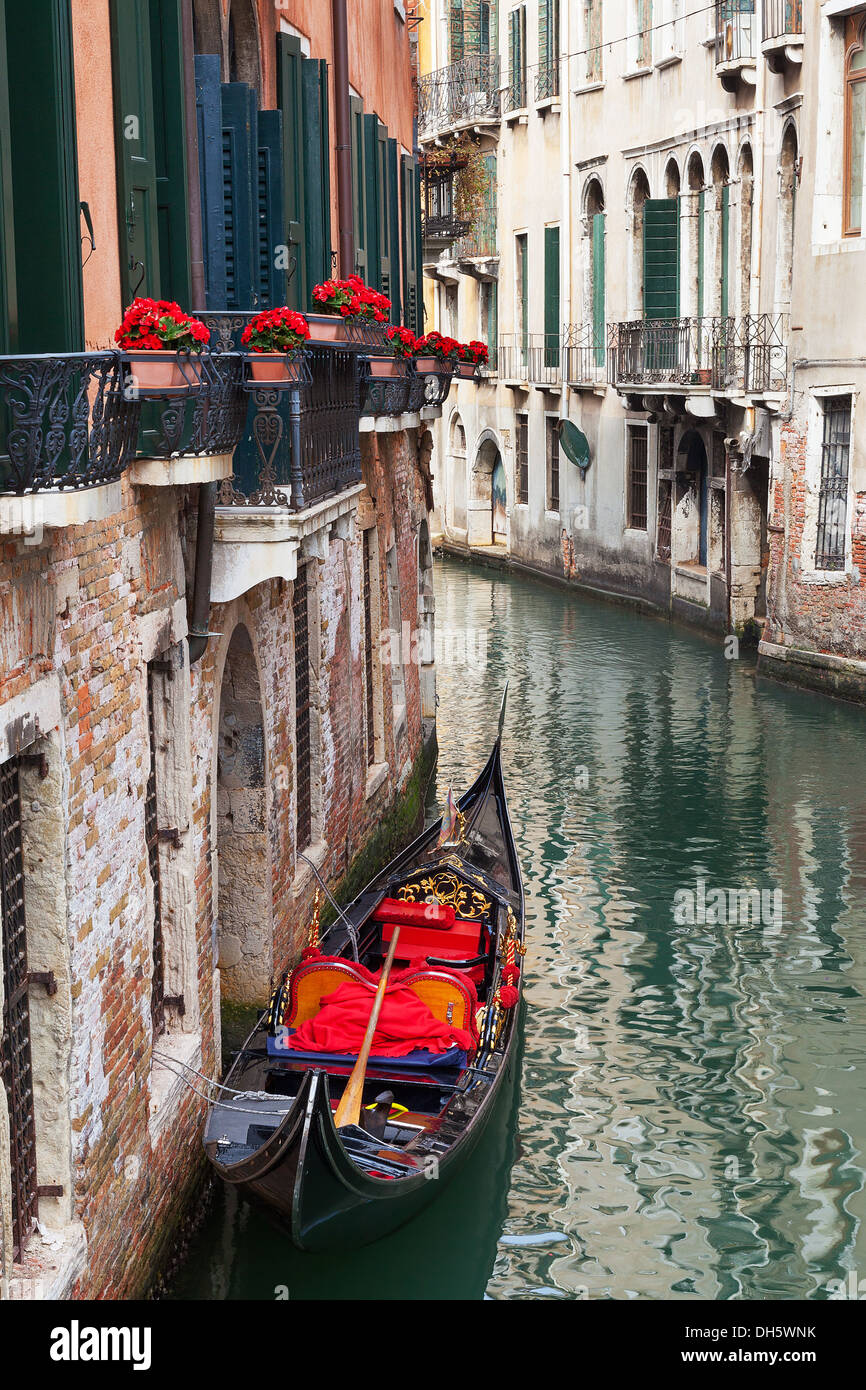 Venetian backstreet canal con gondola vuota Foto Stock