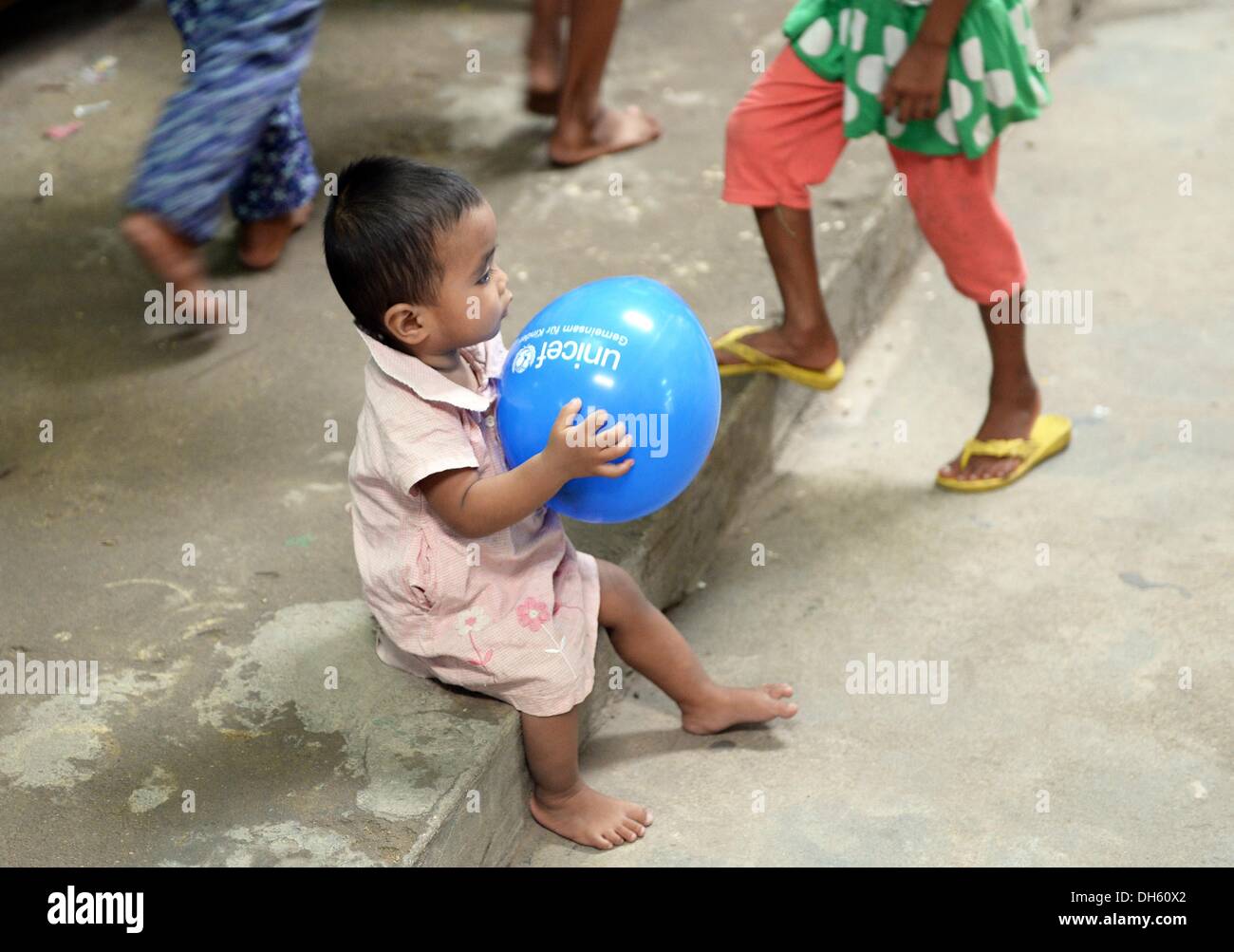 Una ragazza con un palloncino Unicef ride nel progetto per i bambini di strada Mith Samlanh ("Amici"), il quale è supportato da UNICEF, in Phnom Penh Cambogia, 11 ottobre 2013. La Cambogia è tra i venti paesi peggiori in cui i bambini soffrono di malnutrizione. Ci sono circa 670.000 orfani. Ogni 22 bambino muore nel primo anno di vita. Foto: Jens Kalaene Foto Stock