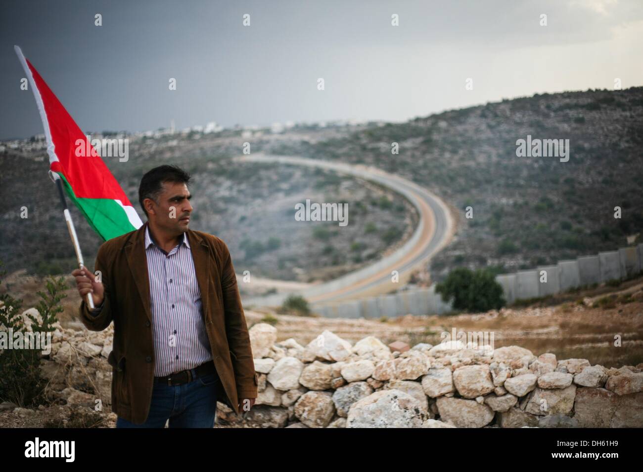 Bilin, West Bank, . 1 Nov, 2013. Un manifestante palestinese mantiene la Palestina bandiera durante scontri in Bil'in seguito Bil'nel settimanale del non violenta manifestazione contro l apartheid, vicino a Ramallah in Cisgiordania, 01 novembre 2013. Tre palestinesi secondo come riferito sono stati feriti durante gli scontri che accompagnano il settimanale venerdì dimostrazioni di palestinesi contro il muro di apartheid.Foto: Hamde Abu Rahma/NurPhoto (credito Immagine: © Hamde Abu Rahma/NurPhoto/ZUMAPRESS.com) Foto Stock