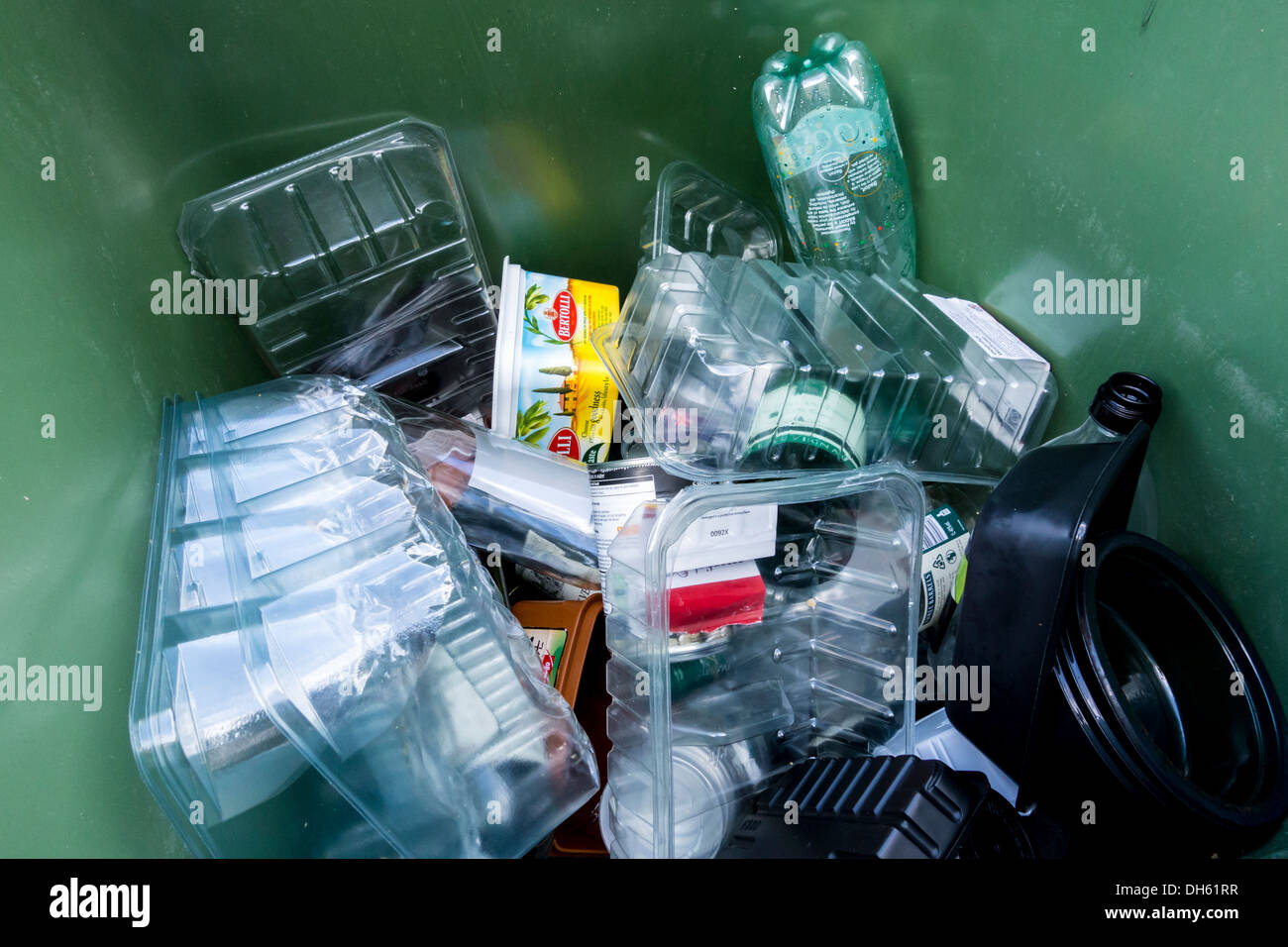 Green wheely cassone pieno di contenitori di plastica alimentare per il riciclaggio raccolta, REGNO UNITO Foto Stock
