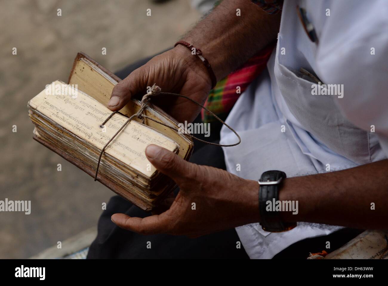 Siem Reap, Cambogia. Xiii oct, 2013. Un Buddista detiene scritto pagine di bambù per una cerimonia nel tempio buddista complesso Angkor Wat vicino a Siem Reap, Cambogia, 13 ottobre 2013. Il tempio è il più grande monumento religioso al mondo ed è stato costruito dal re Khmer Suryavarman II nei primi anni del XII secolo. Nel 1860, le rovine del tempio sono state ritrovate dal ricercatore Francese Henri Mouhot. Foto: Jens Kalaene/dpa/Alamy Live News Foto Stock